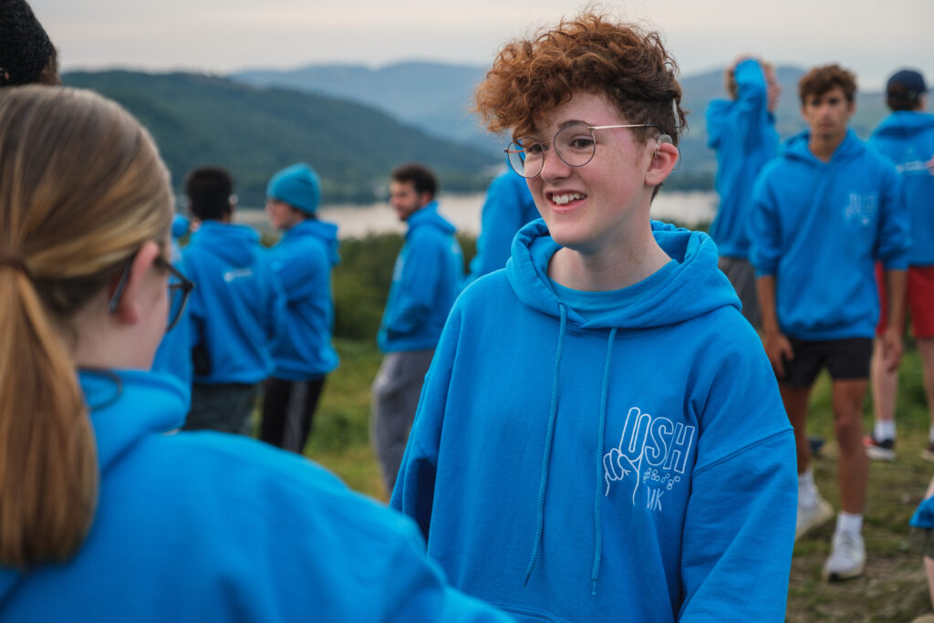 A girl in a blue hoody at summer camp